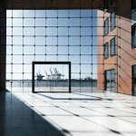 Modern building with glass facade overlooking a harbor