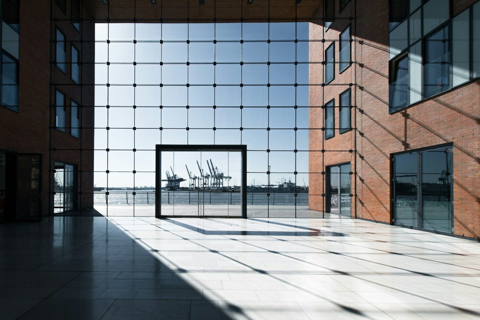 Modern building with glass facade overlooking a harbor